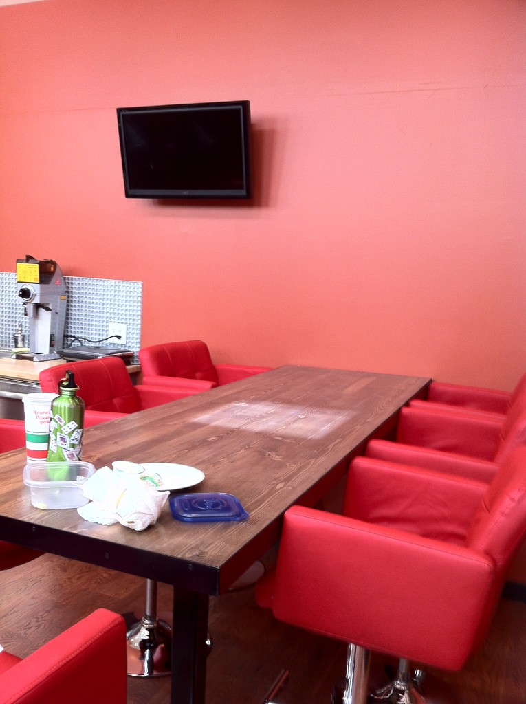 Brightly colored kitchen area with red high-top chairs to match.