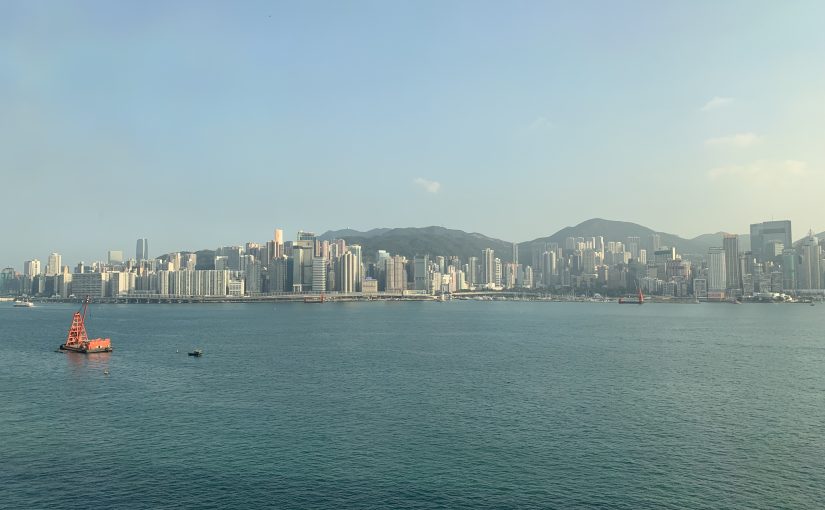 Boats pass by in Victoria Harbour as the Hong Kong cityscape looms behind.