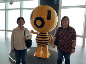 Helene Kwong and her mother standing with the mascot from Taipei 101 Observatory.